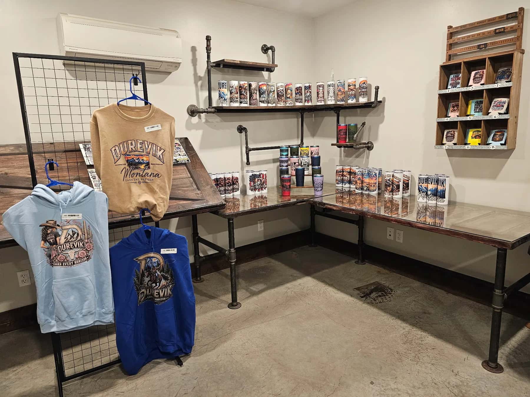 Durevik hoodies on the rack and tumblers on the shelves in a corner of our shop