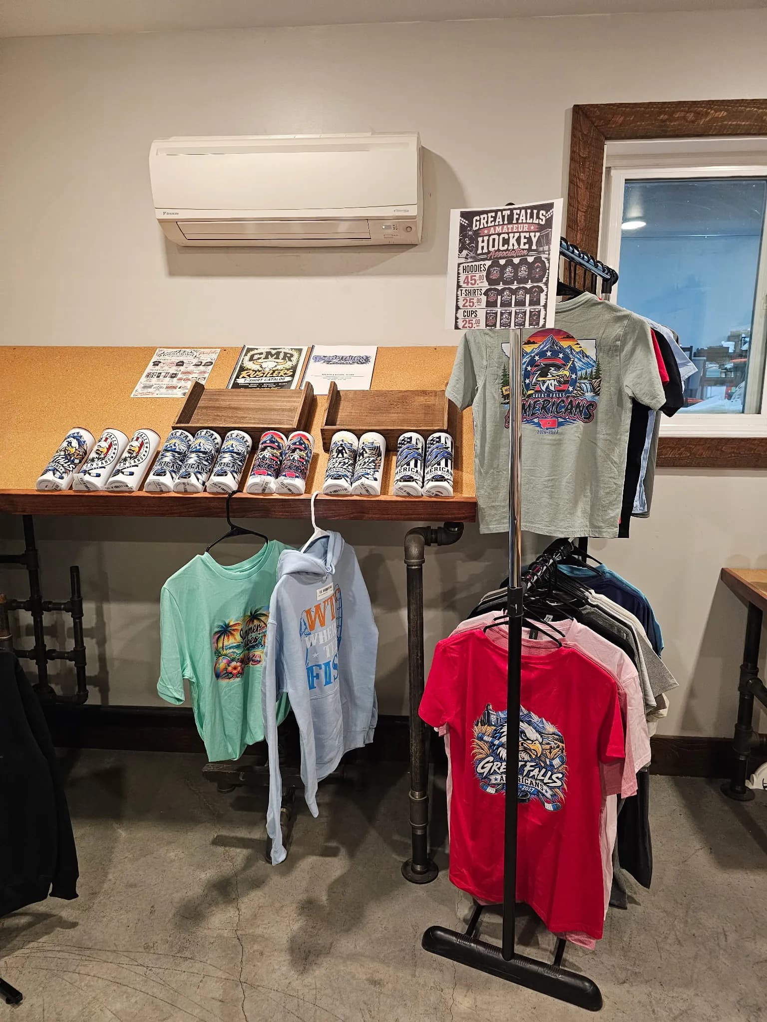 Printed Great Falls tees and a hoodie on the rack in our shop